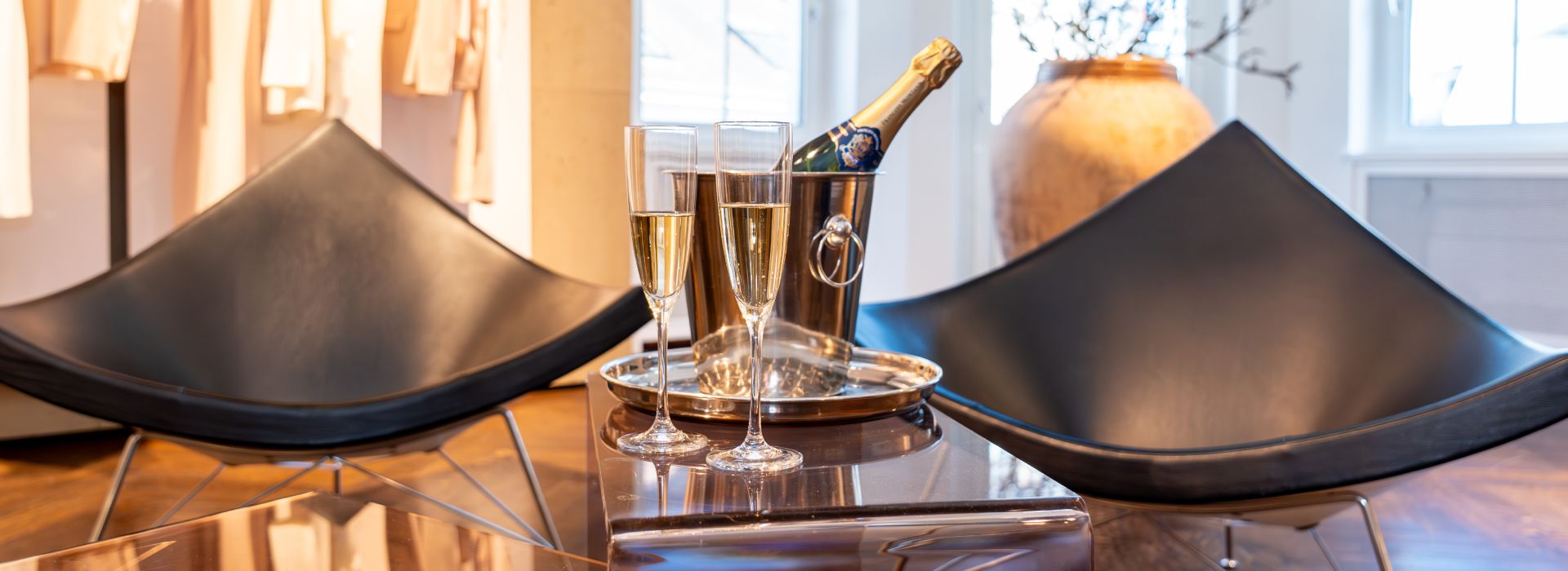 Cozy interior with modern chairs, champagne on table, and soft lighting ambiance