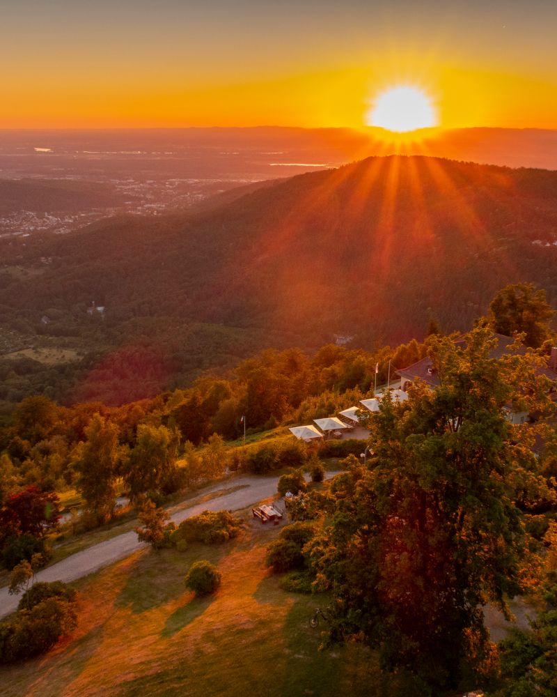 Stunning sunset over mountains with sunlight illuminating hills and a winding road