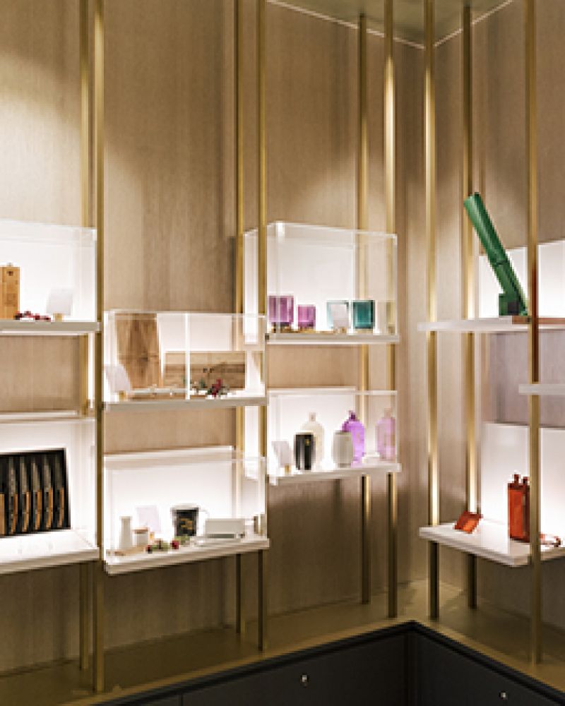 Modern glass shelves with decorative items on light wood background