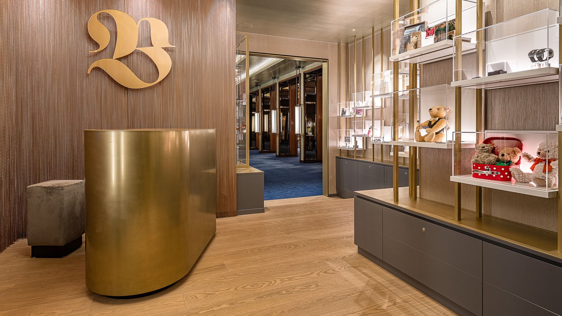 Modern reception with a golden desk, artistic '23' logo, shelves with plush toys.